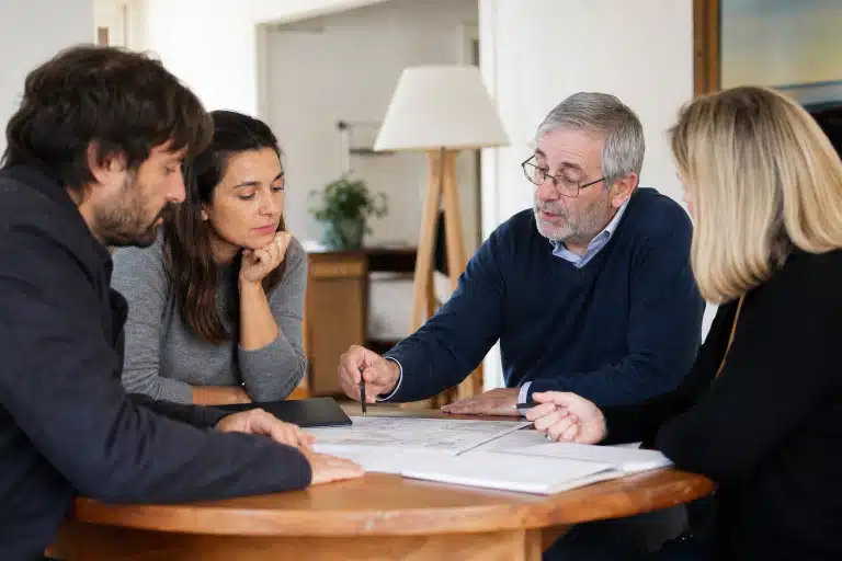 Homme âgé montrant des documents à un couple
